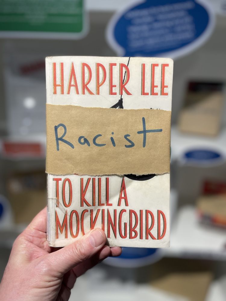 Book partially covered with brown paper with a handwritten accusation of 'racist'