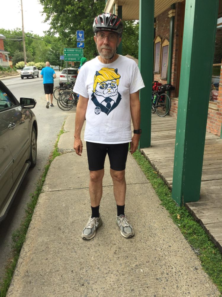Paul Krugman wearing a bicycle helmet with a shirt that reads "Trumpy Cat"