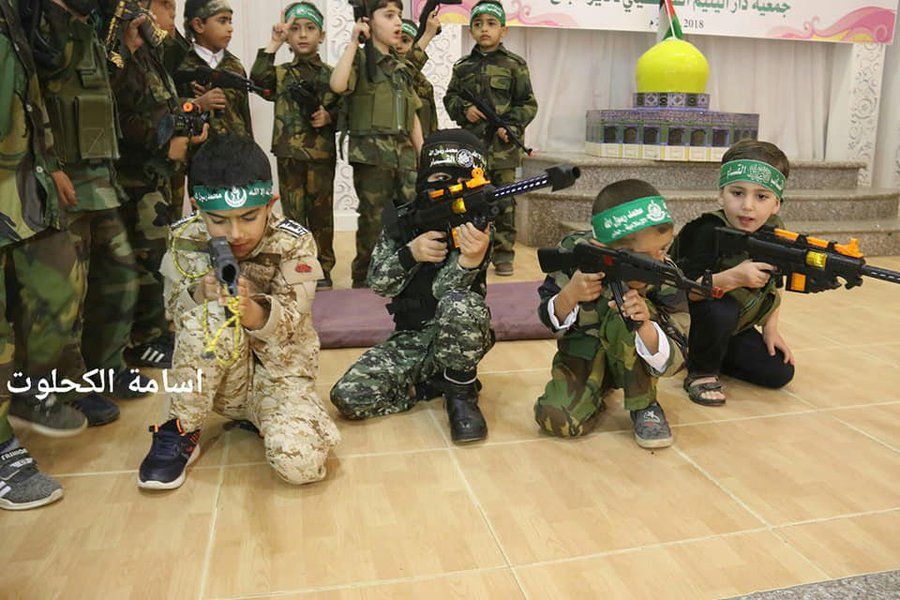 Image of little boys in Gaza dressed as soldiers, with "martyr"-headbands and guns.
