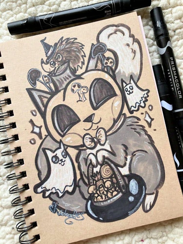 A photo of a tan paper sketchbook drawing. In gray scale, a tuxedo cat with a pumpkin head and long fluffy tail holds a bucket of Halloween candy. White cat ghosts and sparkles are around the cat. A hedgehog with a witch hat sits on its head. 