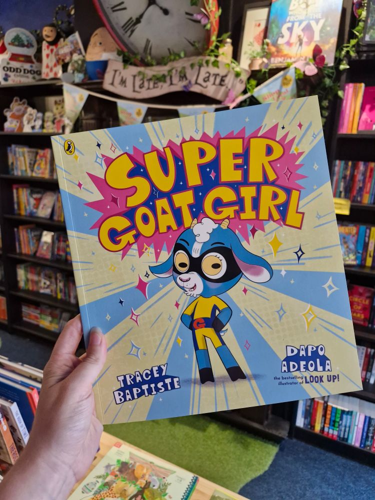 Photo of Super Goat Girl by Tracey Baptiste and Dapo Adeola being held up in Wonderland Bookshop. 