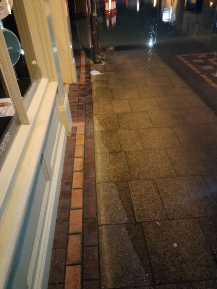 Flood waters moving up high street. 