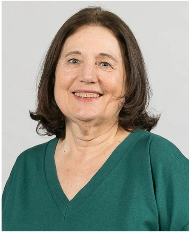 Headshot of a woman in a green shirt.