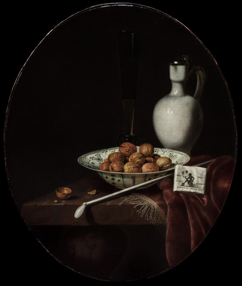 Dark painting of a porcelain bowl filled with walnuts in the middle, stoneware jug, a tall glass, a long-stemmed pipe, and a tobacco wrapper.