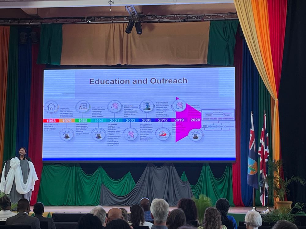 Photograph of Dr Pat Joseph, director of the UWI seismic research centre, in front of a slide of volcano education and outreach projects on St Vincent, during the opening plenary lecture at SHV30, Montserrat 