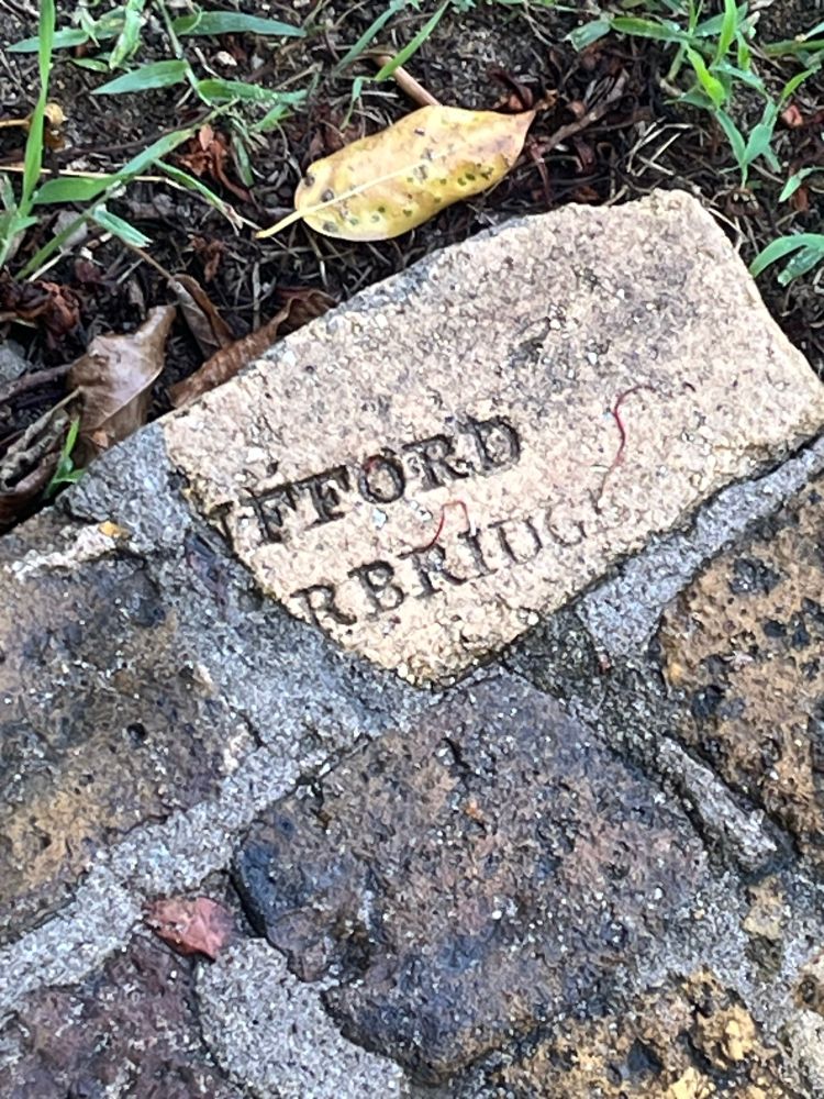 Photograph of some bricks, one of which is made from yellow clay with the partial impression [RU]FFORD [STOU]RBRIDGE, near the colonial-era bakery building on Pigeon Island, St Lucia. 