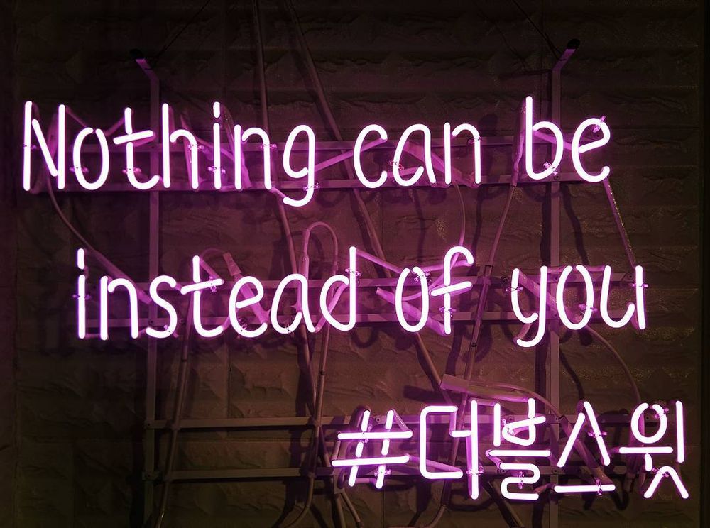a fluorescent sign that says "nothing can be instead of you" with a hashtag in Korean underneath