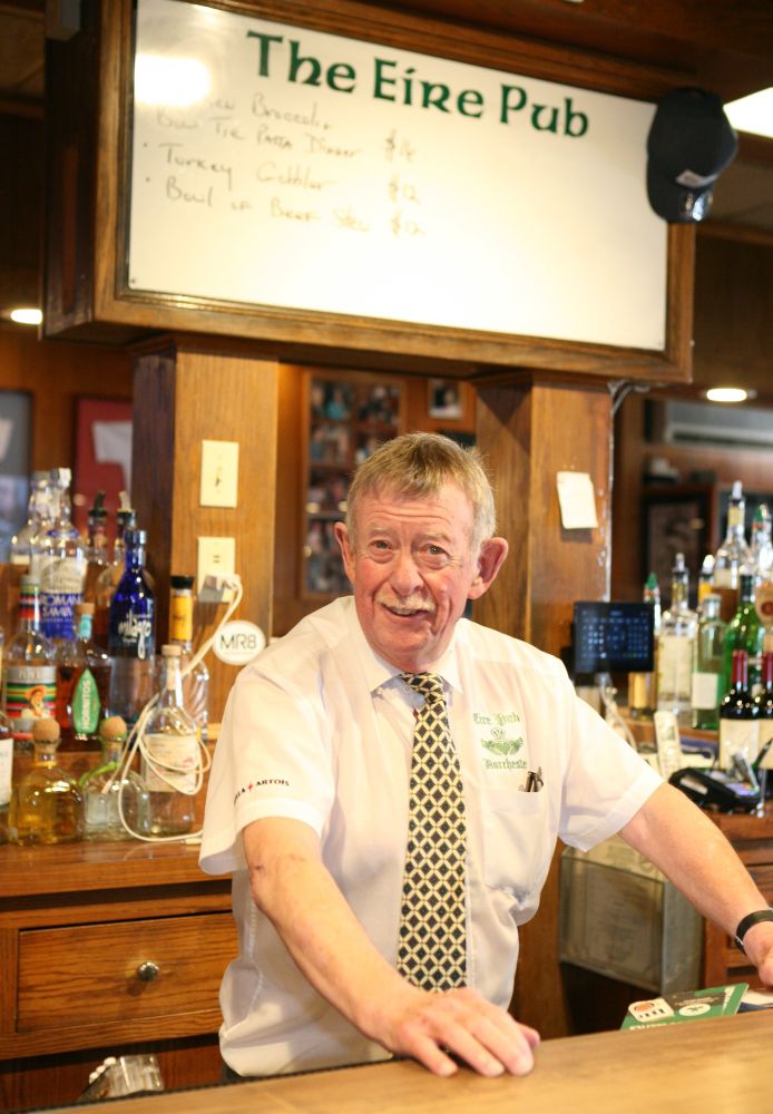 Johnny Curran at his familiar place behind the Eire Pub bar last Thursday, collared shirt and tie in place, working his last shift at the storied neighborhood pub in Adams Village. Seth Daniel photo