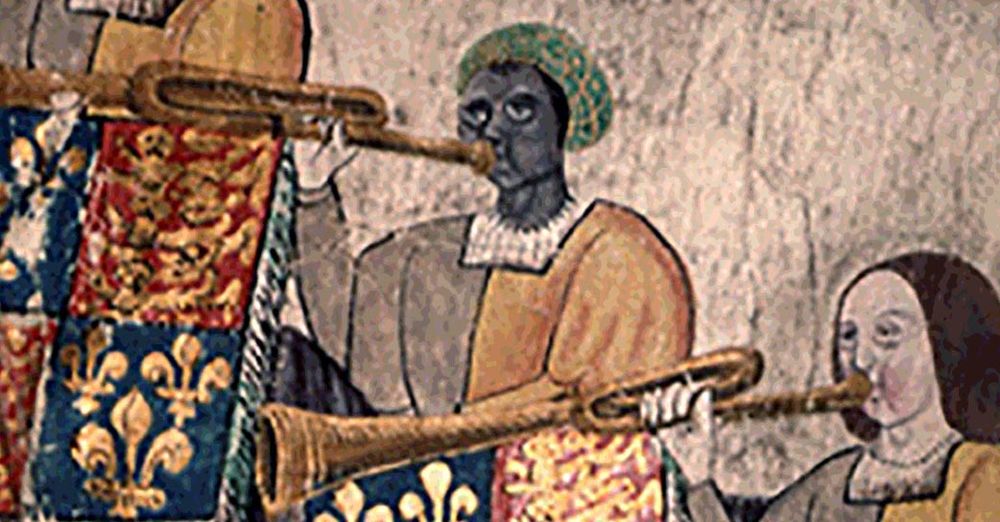 John Blanke, trumpeter to the court of Henry VIII, in a painting of the period. He is a black man, wearing the orange & grey livery of a courtier, and a green & gold turban. He’s playing a trumpet from which hangs a banner of the royal coat of arms.