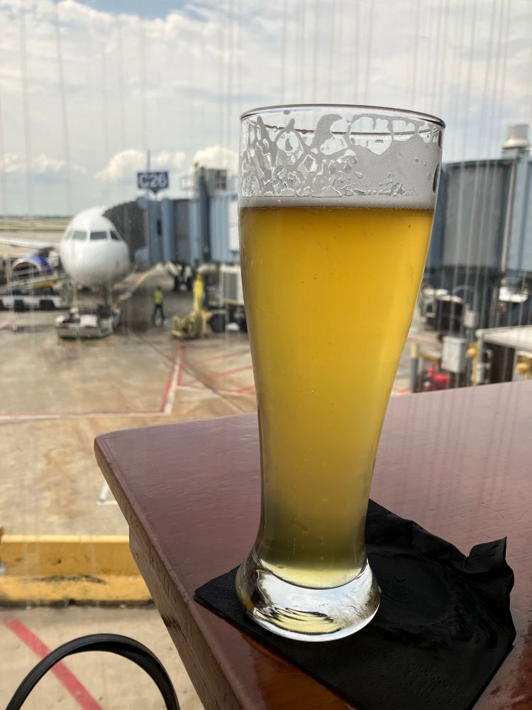 Pint of beer with a plane in the background. 