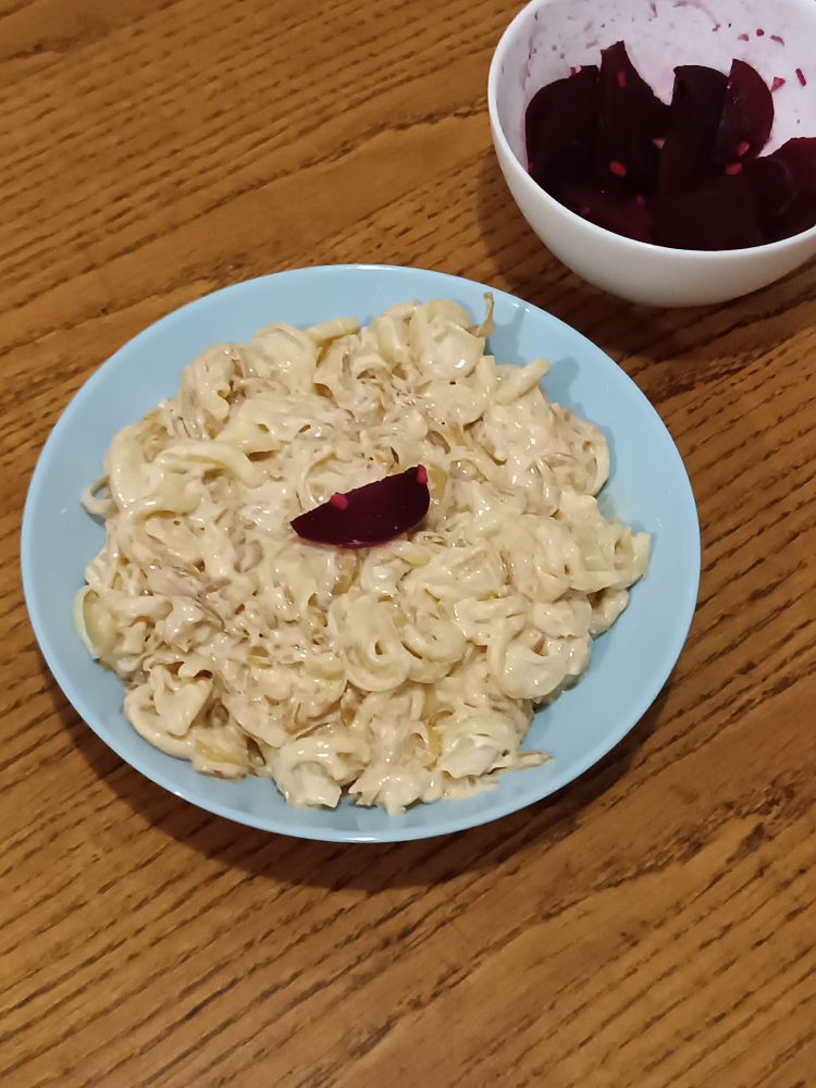 Creamy caramelized onion and cheese pasta with a side of beetroot salad, one piece of it on top of the pasta as a garnish :3