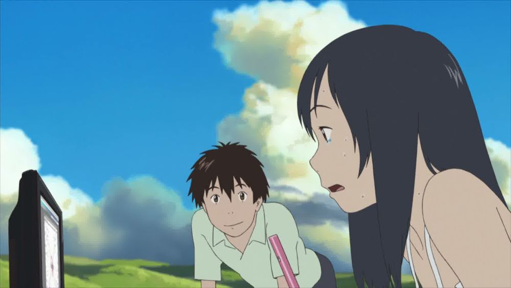 Young hero Kenji gazes longingly at his teenage beloved Natsuki, sat at a computer, in a scene from Mamoru Hosoda's 2009 animation SUMMER WARS.