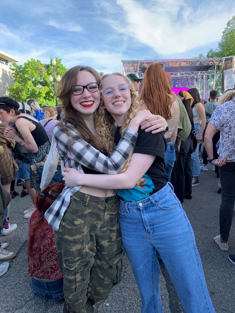 A photo of me and bee at a small outdoor concert together when we first met. We are hugging eachother close. 