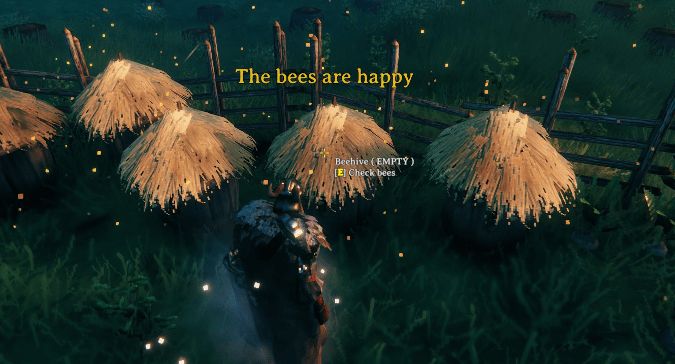 Cropped screenshot from Valheim, featuring a character interacting with a beehive getting the text pop-up "The bees are happy"
