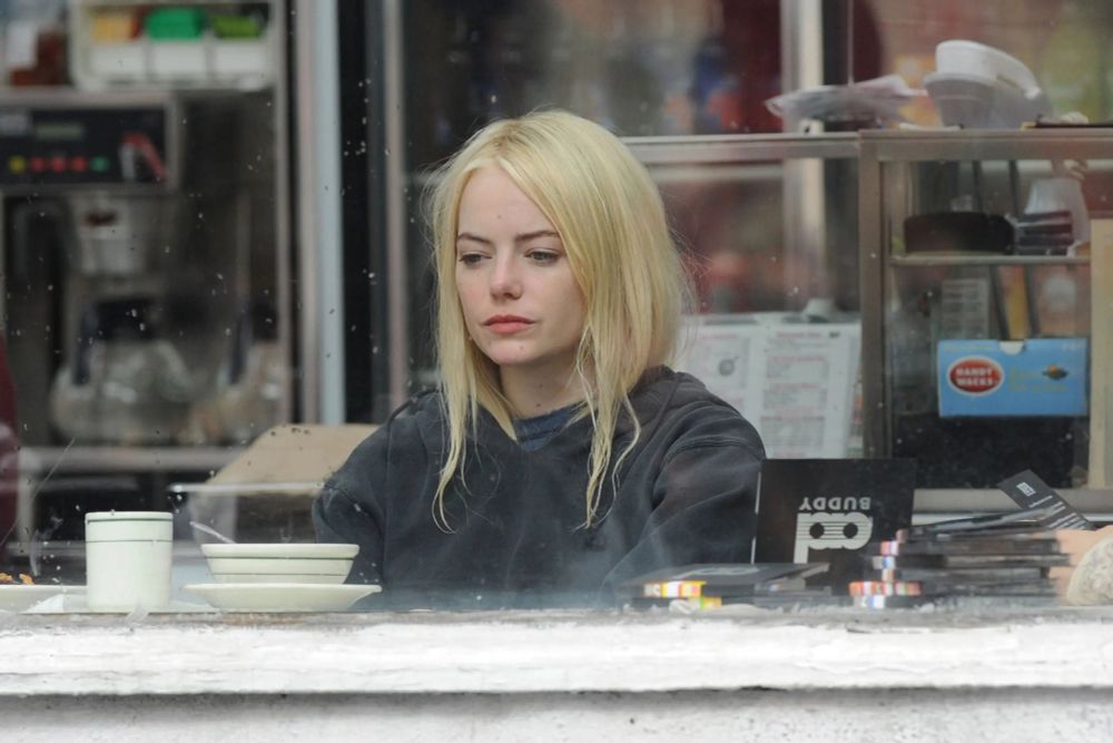 Emma stone ( Blonde Woman) in deep thought at a diner