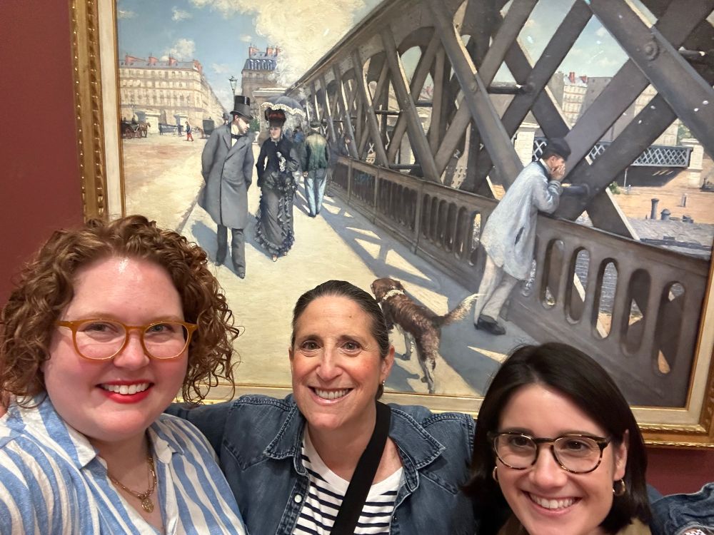 3 women in front of Gustave Caillebotte’s painting Le Pont de L’Europe. 