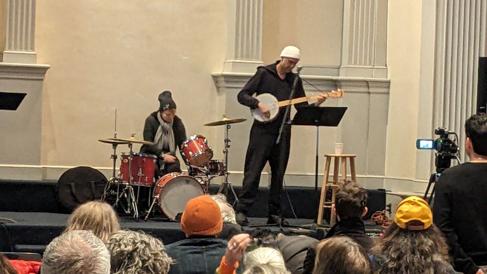 Shazad Ismaily plays banjo while Georgia Hubley drums