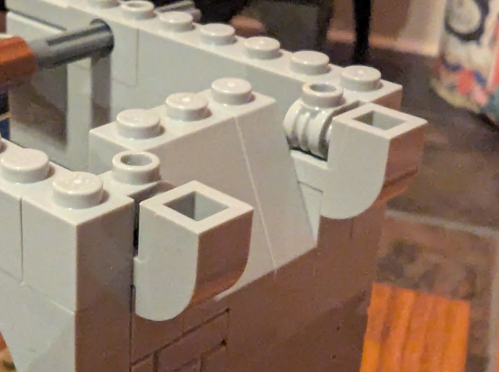 Grey Lego curved slope bits upside down held in place by scroll bricks