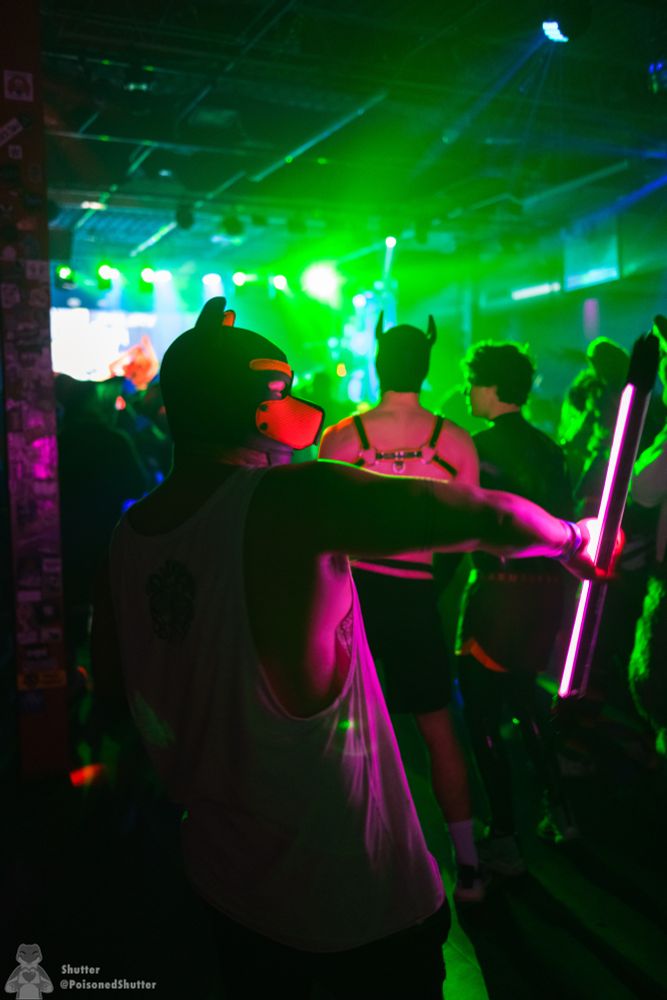 Human pup twirling rave lights on the dance floor.