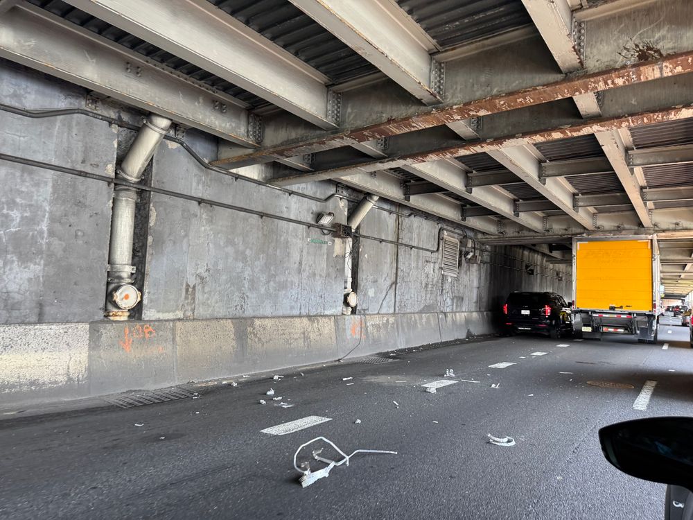 Debris fallen off a truck now stuck under an overpass 