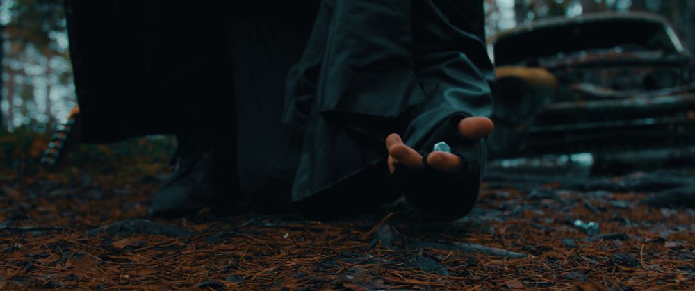 A photo of me kneeling down in the woods and picking up a bolt