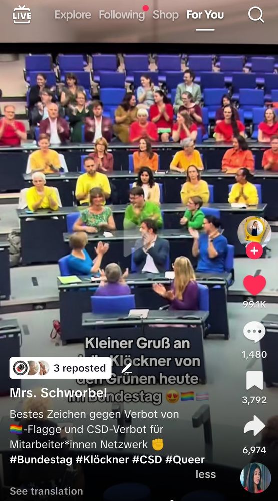 Screenshot eines TikTok-Videos, aufgenommen im Deutschen Bundestag. Zu sehen sind zahlreiche Abgeordnete, die in den Farben der Regenbogenflagge gekleidet sind. Der untere Bildtext lautet: „Kleiner Gruß an Julia Klöckner von den Grünen heute im Bundestag“, ergänzt durch Regenbogen-Emojis und Herzen. Die TikTok-Überlagerung zeigt den Accountnamen „Mrs. Schworbel“ sowie den Kommentar: „Bestes Zeichen gegen Verbot von Regenbogen -Flagge und CSD-Verbot für Mitarbeiter*innen Netzwerk“.

