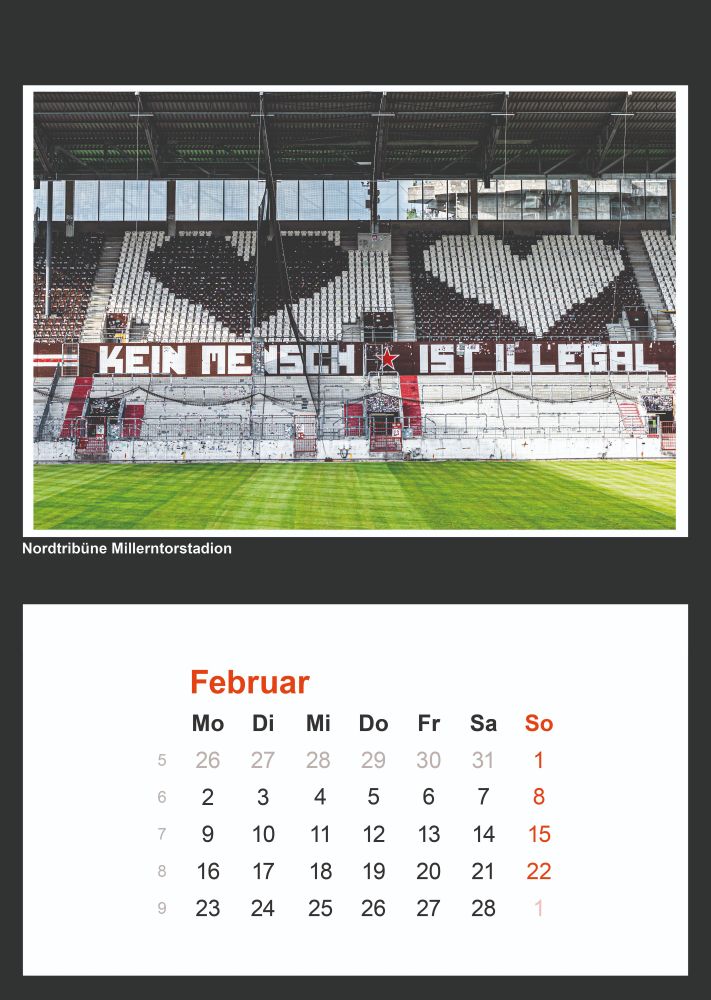 Ein Foto der Nordtribüne im Millerntor-Stadion, der Heimat des FC St. Pauli in Hamburg. Die Sitzreihen im Hintergrund sind in einem Muster aus Schwarz und Weiß angeordnet, das ein großes Herz bildet. Quer über die unteren Ränge des Stadions erstreckt sich ein großes Spruchband mit dem Text "KEIN MENSCH IST ILLEGAL" in schwarzen und roten Buchstaben auf weißem Grund. Darunter befindet sich ein Kalenderblatt für den Monat Februar.