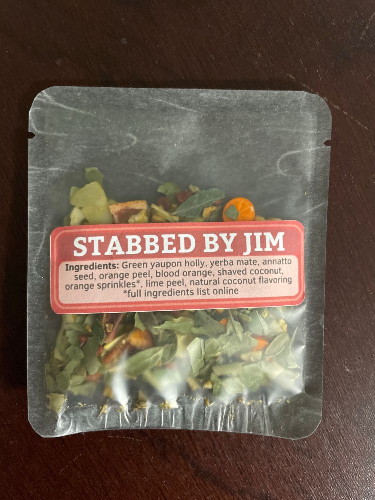 A sample bag of loose leaf tea named STABBED BY JIM from Friday Afternoon Tea. 
Ingredients: Green yaupon holly, yerba mate, annatto seed, orange peel, blood orange, shaved coconut, orange sprinkles*,
, lime peel, natural coconut flavoring
*full ingredients list online
