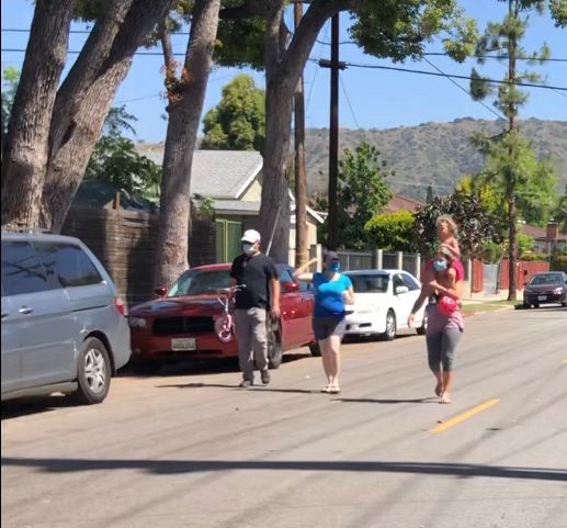 Pedestrians walking 3 abreast in roadway on a Slow Street during the height of COVID in the summer of 2020