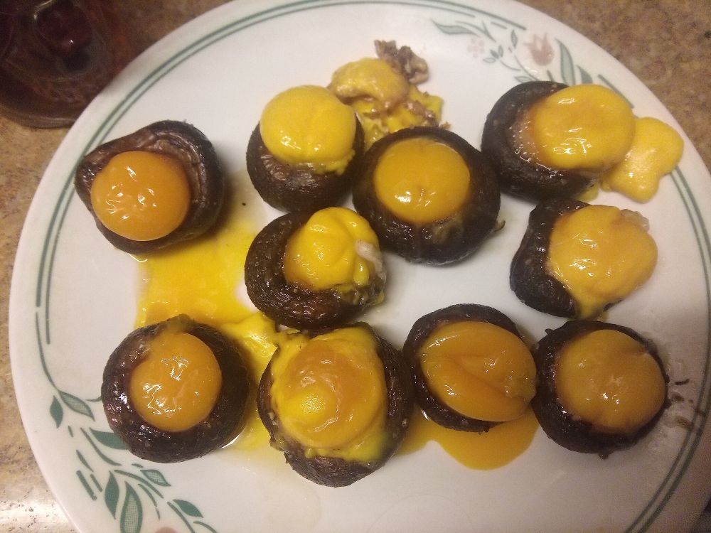 Egg yolks in crimini mushrooms that have been baked in the oven.