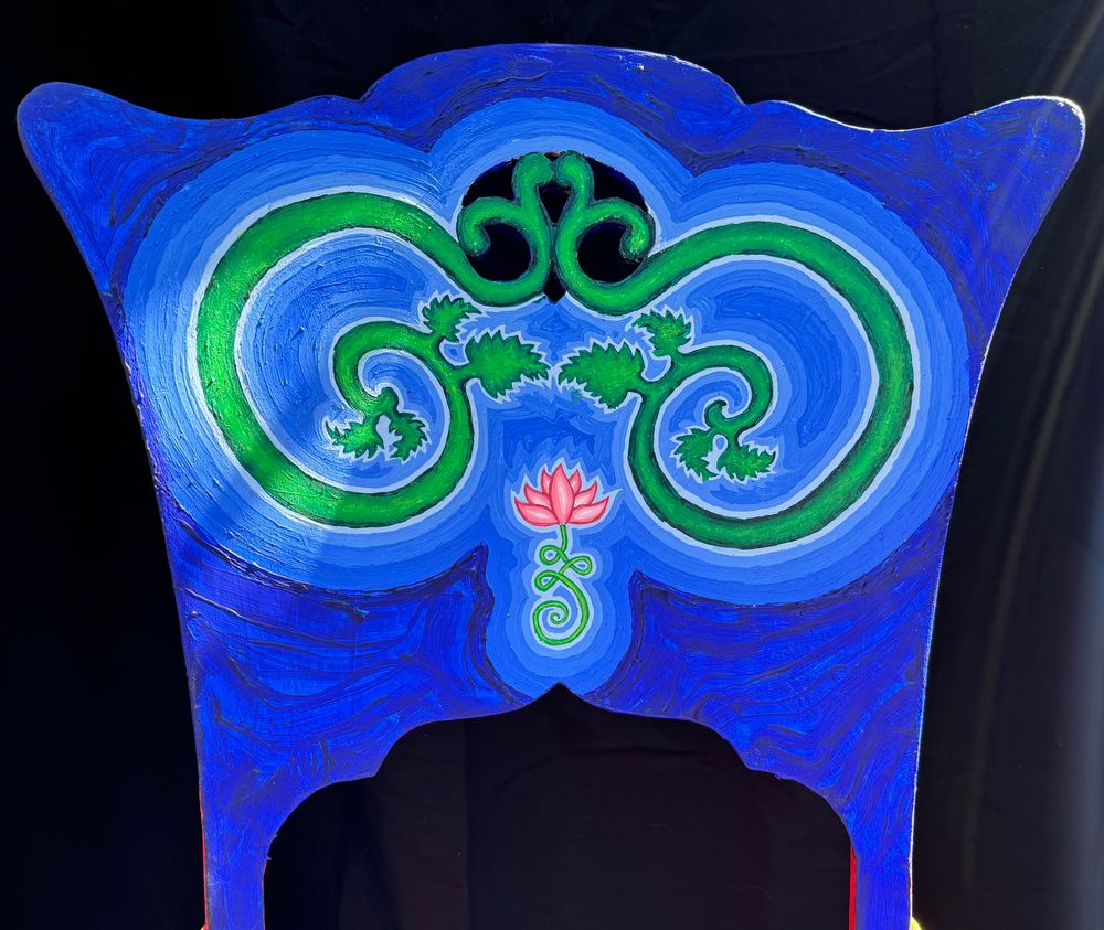 Rocking chair painted blue with green vines and pink lotus