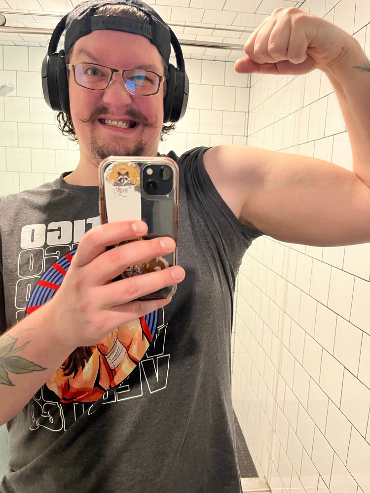 Selfie of Mike bicep flexing in the gym mirror