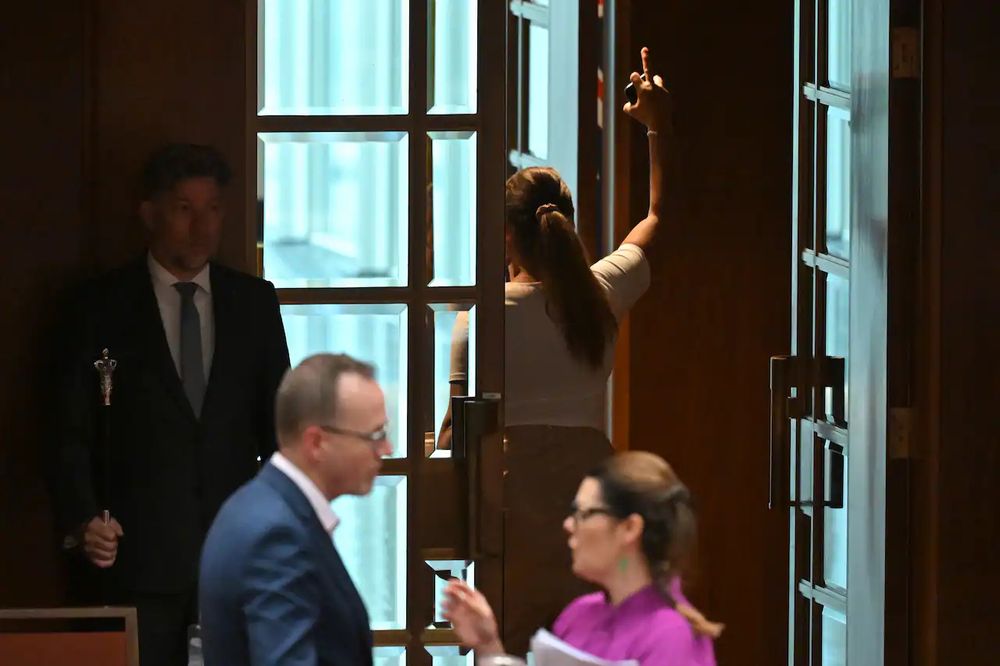 A fierce picture of Lidia Thorpe walking out of the senate with her third finger proudly in the air. 
