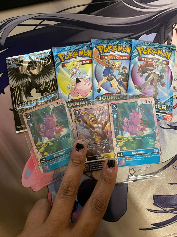 Digimon TCG participation cards and packs of Pokémon TCG cards 