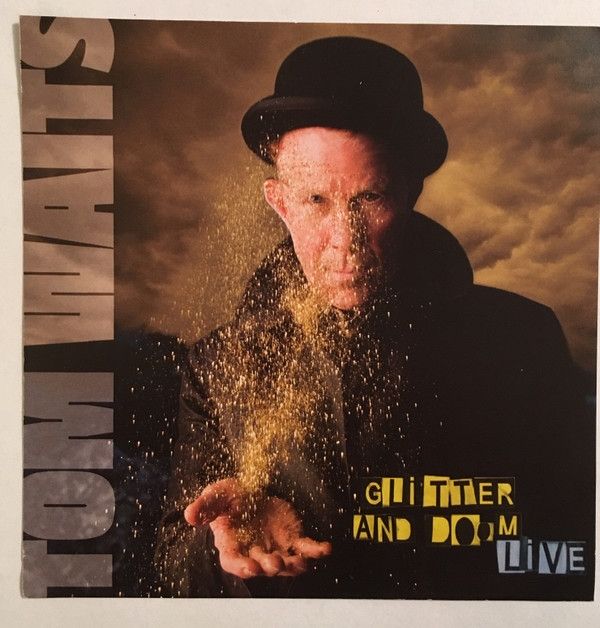 An old man dressed in black with a black hat holding out a hand spreading glitter. 
This is the album cover to Glitter And Doom by Tom Waits