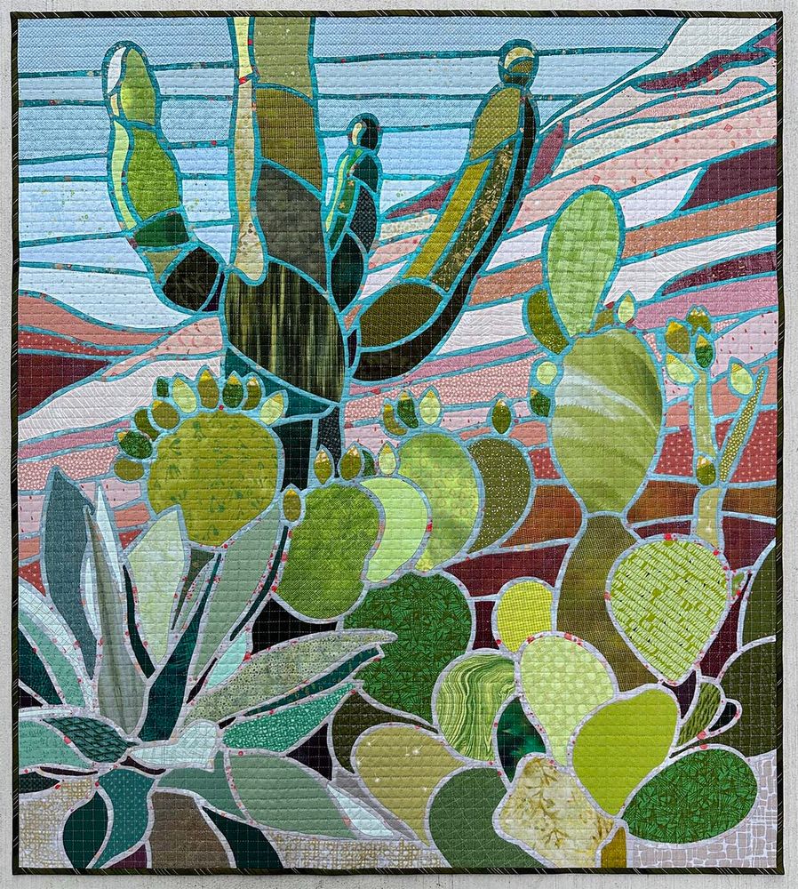 37" x 41"

Description: Photographs of desert plant life at a Nevada botanical garden combined with the red rock formations of Southern Utah inspired this needle-turn appliqué quilt. Using AutoCAD, I translated these images into a template line drawing. As I turned the edges of each fabric section under during the stitching process, the gradient background was revealed, creating a stained glass-like effect. The gridded quilting is reminiscent of observing the outdoor world through a window screen.