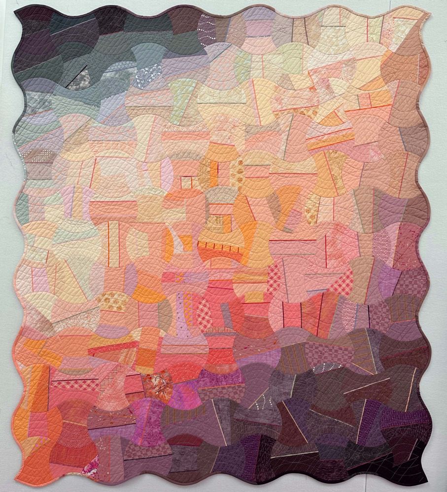 Description: How does an up-and-coming color trend meld with a traditional shape? For my 2024 100-Day Quilt, I used the Pantone Color of the Year, Peach Fuzz, in a design featuring Apple Core Blocks. I improvisationally pieced rectangles of fabric for individual blocks before using an Accuquilt to cut the final apple core shape. The piecing within each block enhances the unexpected diagonal gradient that moves across the quilt.