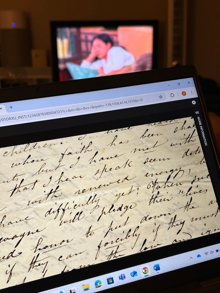 Computer screen with 19th century handwritten letter and a tv screen with the Bachelor on in the background.
