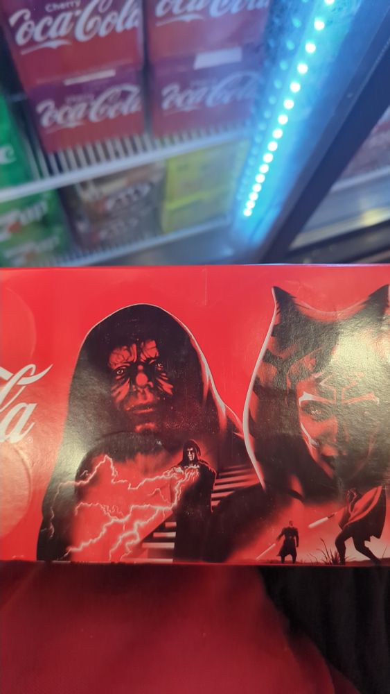 A twelve pack of Coca-Cola with limited edition star wars printing, showing darth sidious looking horribly dishevelled, even for palpatines standards.