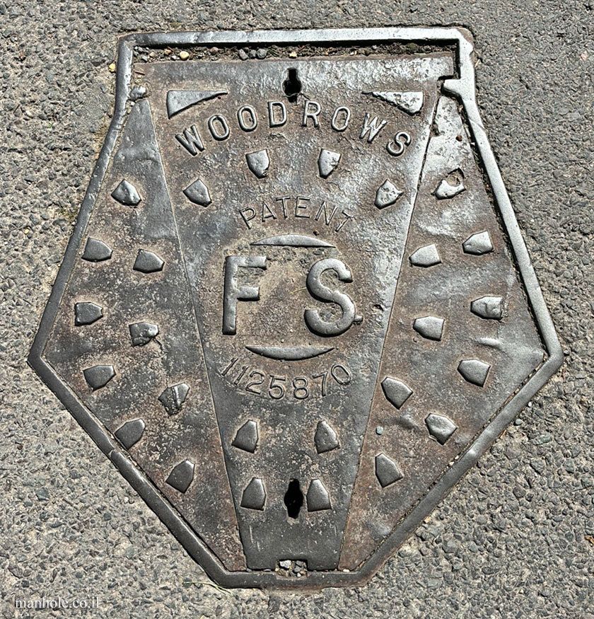 Pentagon shape manhole cover with text on it saying
Woodrows
Patent 1125870
FS
