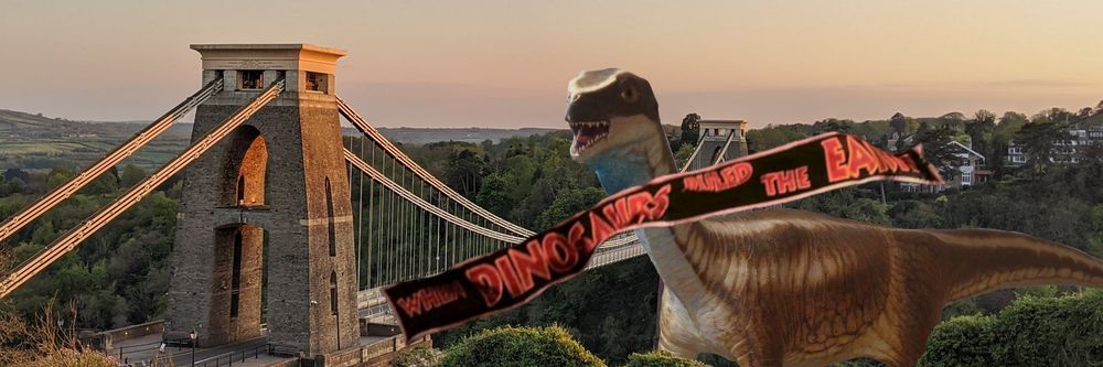 A giant Thecodontosaurus standing next to Clifton Suspension Bridge with the "When Dinosaurs Ruled The Earth" banner from Jurassic Park
