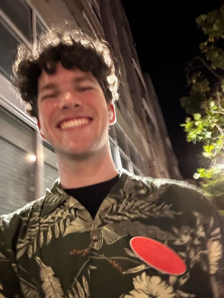 A picture of smiley me, dressed in a hawaiian shirt and trader joe's nametag