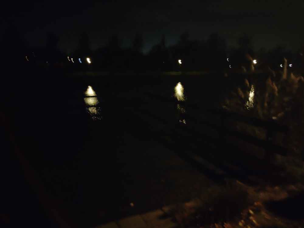 It is dark, but there is some light from some houses