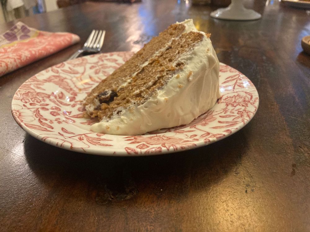 A slice of carrot cake on a plate on a table