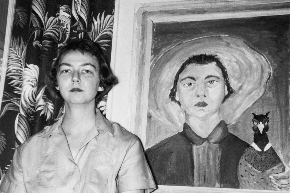 Young Flannery O'Connor standing next to painting of her with peacock