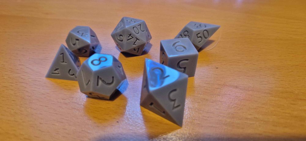 A set of 3d printed dice. Printed in grey resin and polished