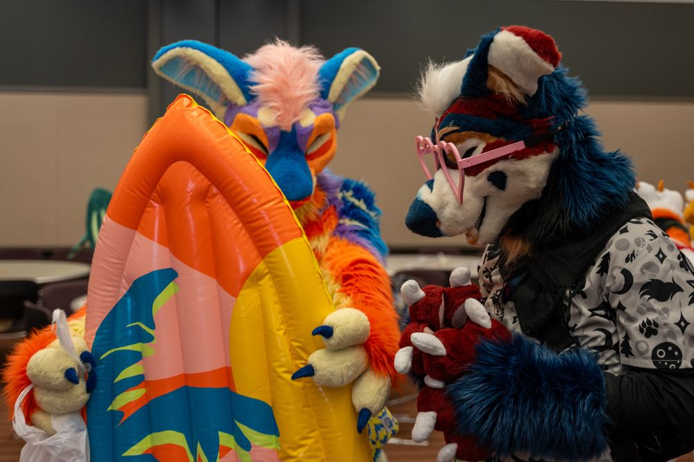 A brightly colored sunset manokit showing a surfboard to a blue, red, and white manokit