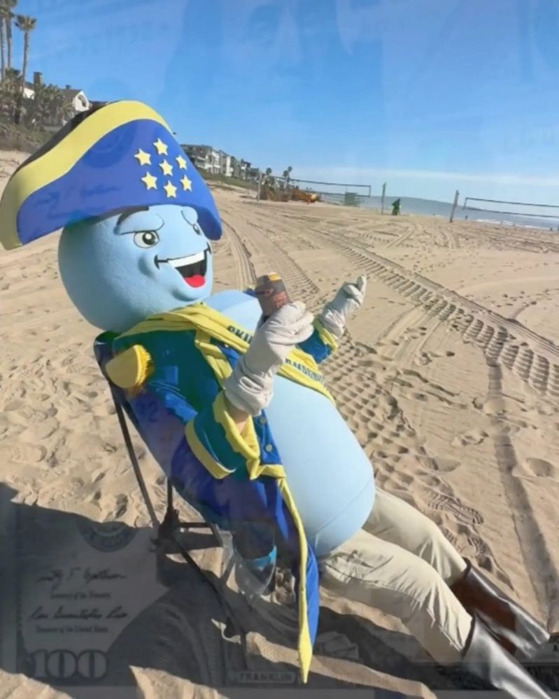 I... I don't know how to describe this...
It's a person with a light blue sphere for a head with a cartoonish face, and a light blue cylinder for a body. The person is in a blue and yellow admiral's coat and hat, drinking a beer on the beach, with very faint images of large 100 dollar bills overlaid on top.

You will be getting no context. Enjoy. 