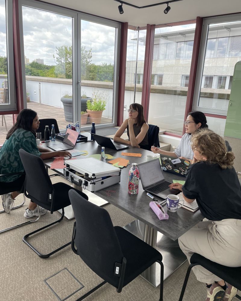Picture of the participants sitting around a table at a conference room at CAIS