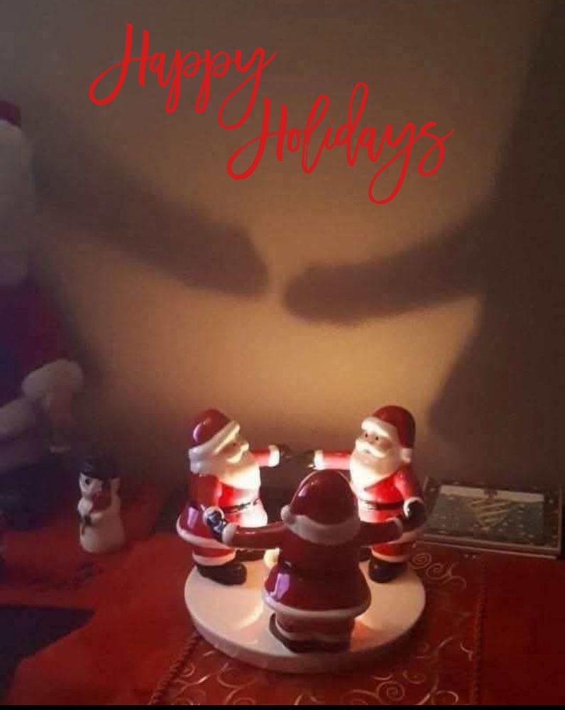 Happy Holidays

Three Santa’s standing around a lit candle, the shadow of the Santa’s arms on the wall behind them looks like two penises. 